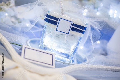 Tableau sur toile Lighted jar with confetti with white label to personalize image, rope for decoration and cone for confetti on blue table
