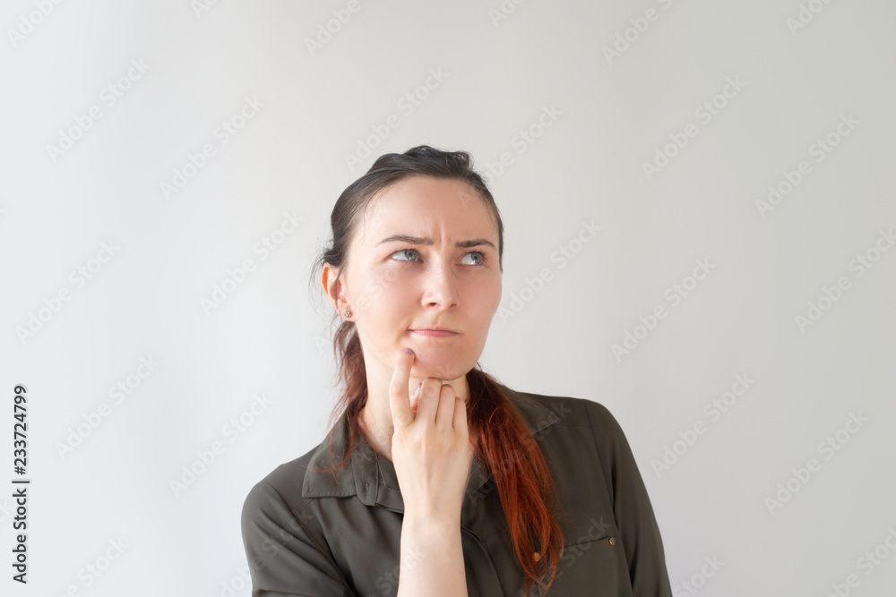 Pensive pretty Caucasian manager touching chin and frowning. Portrait of young female specialist looking aside in search of solution. Startup concept Pensive pretty Caucasian manager touching chin and frowning. Portrait of young female specialist looking aside in search of solution. Startup concept