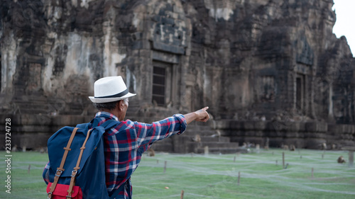 Senior man Asian with backpack are walking at Phra Prang Sam Yot. Ancient and historical attractions and one of the most important archaeology of Lopburi province thailand. Travel, Tourist Concept