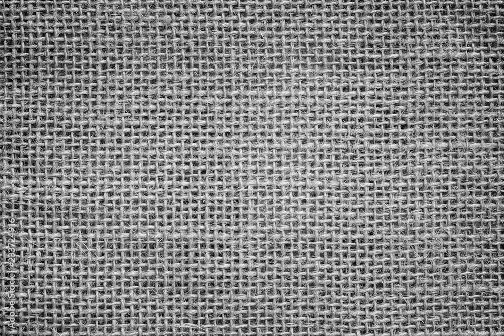 Close-up of a burlap jute canvas full frame background with vignetting in black and white. Close-up of a burlap jute canvas full frame background with vignetting in black and white.