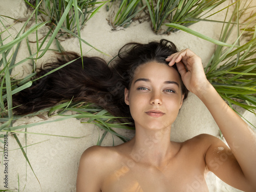 Free happy woman on the beach enjoying nature of tropical island. Natural beauty girl outdoor. Enjoyment of summer trip concept. Gorgeous mixed race Caucasian Asian girl posing on travel vacation
