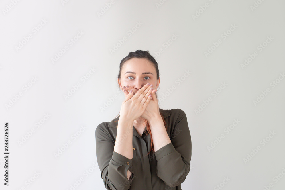 Scared pretty Caucasian woman covering mouth with hands. Young girl in casual shirt reacting to frightening accident. Deep shock concept Scared pretty Caucasian woman covering mouth with hands. Young girl in casual shirt reacting to frightening accident. Deep shock concept