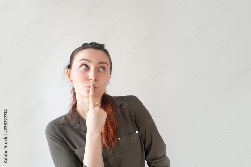 Thoughtful pretty Caucasian woman holding finger near mouth and looking up. Young female student keeping secret from friends. Secret knowledge concept Thoughtful pretty Caucasian woman holding finger near mouth and looking up. Young female student keeping secret from friends. Secret knowledge concept