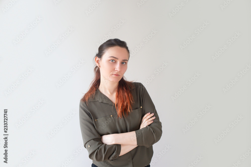 Tired young Caucasian woman crossing arms and looking at camera. Attractive female assistant displeased with workload. Too many duties concept Tired young Caucasian woman crossing arms and looking at camera. Attractive female assistant displeased with workload. Too many duties concept