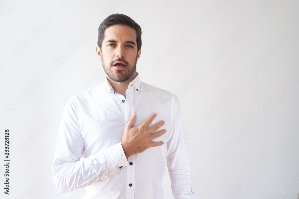 Young Caucasian politician singing and pressing hand to heart. Government official in white shirt performing hymn. Patriot concept Young Caucasian politician singing and pressing hand to heart. Government official in white shirt performing hymn. Patriot concept