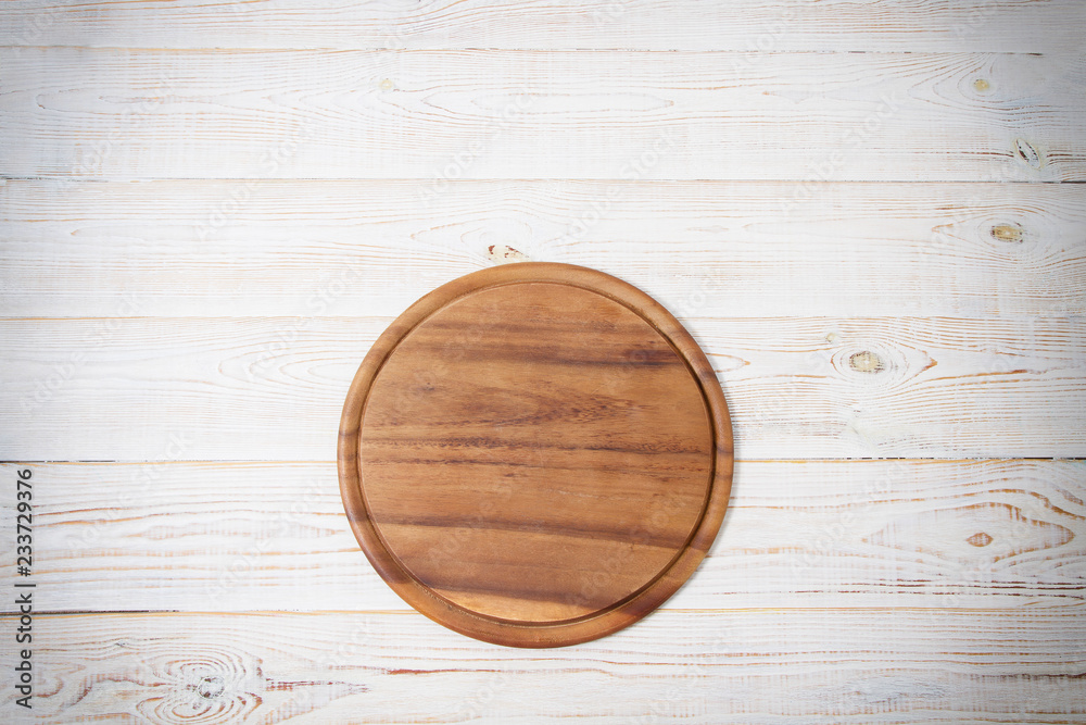 Round pizza cutting board on kitchen white wooden table background. Top view and copy space. Round pizza cutting board on kitchen white wooden table background. Top view and copy space.