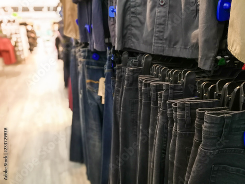 Asian woman shopping in supermarket store and buy Jeans,blur background