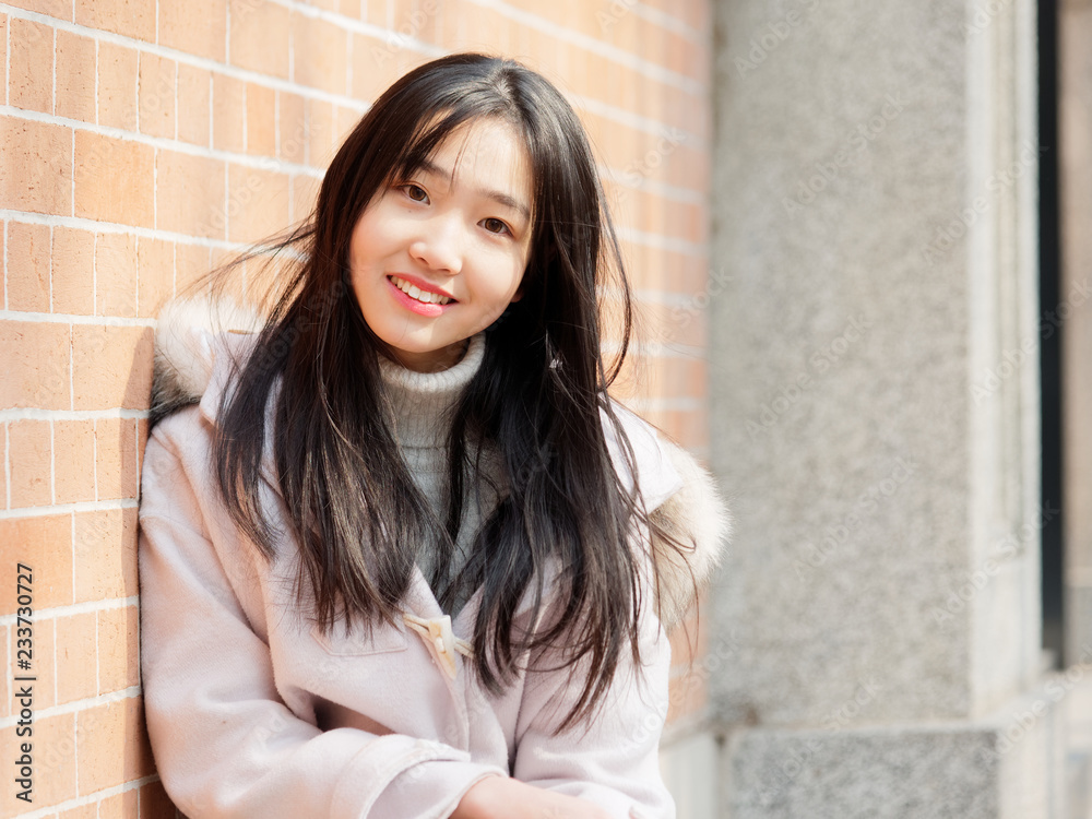 Portrait of beautiful young brunette woman in white winter fluffy coat. Outdoor fashion glamour Chinese teenage stylish lady. Emotions, people, beauty and lifestyle concept. Portrait of beautiful young brunette woman in white winter fluffy coat. Outdoor fashion glamour Chinese teenage stylish lady. Emotions, people, beauty and lifestyle concept.