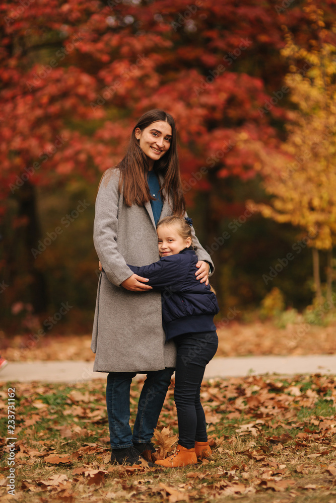 Two sisters walk in the park in autumn time. Childhood. season and people consept-happy family Two sisters walk in the park in autumn time. Childhood. season and people consept-happy family