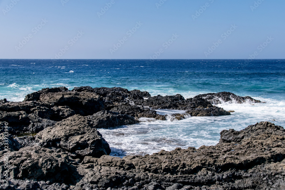 Atlantic ocean waves crashing over volcanic lava rocks on La Palma Island, Canary Islands, Spain