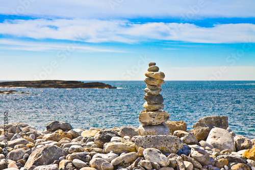 Calm sea with zen stones against a natural landscape - image with copy space