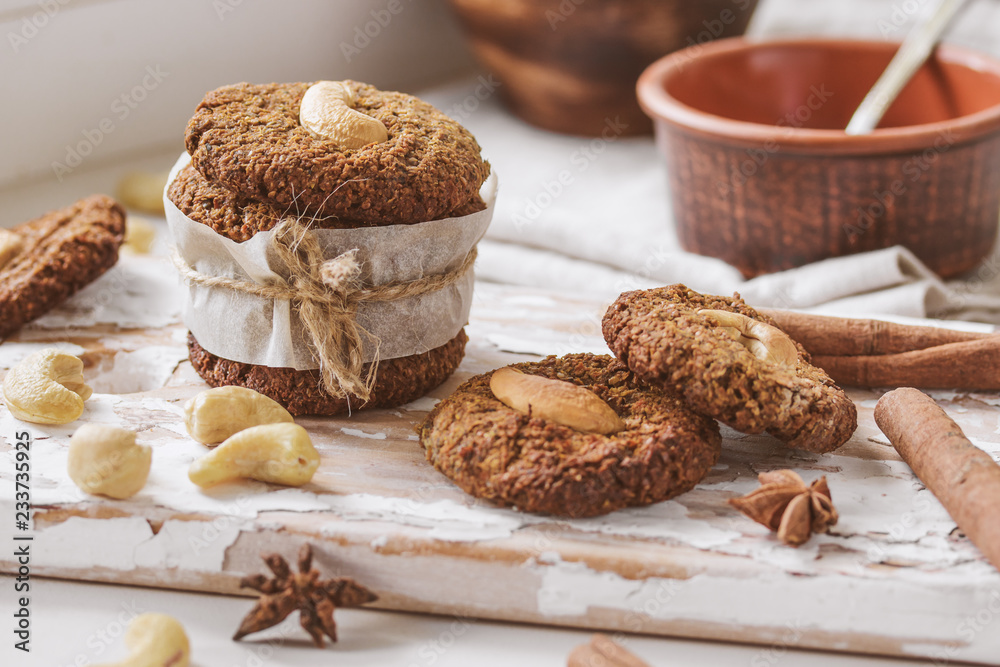 Homemade nutty vegan cinnamon cookies on white beige wooden board, close-up, natural light Homemade nutty vegan cinnamon cookies on white beige wooden board, close-up, natural light