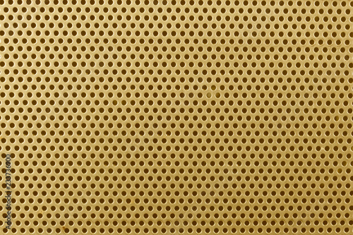 close up on a golden metalic sheet texture with small holes