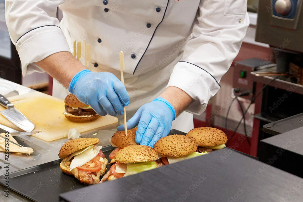 The chef prepares many hamburgers on the table in the restaurant.