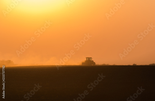 Plowing of stubble field at sunset