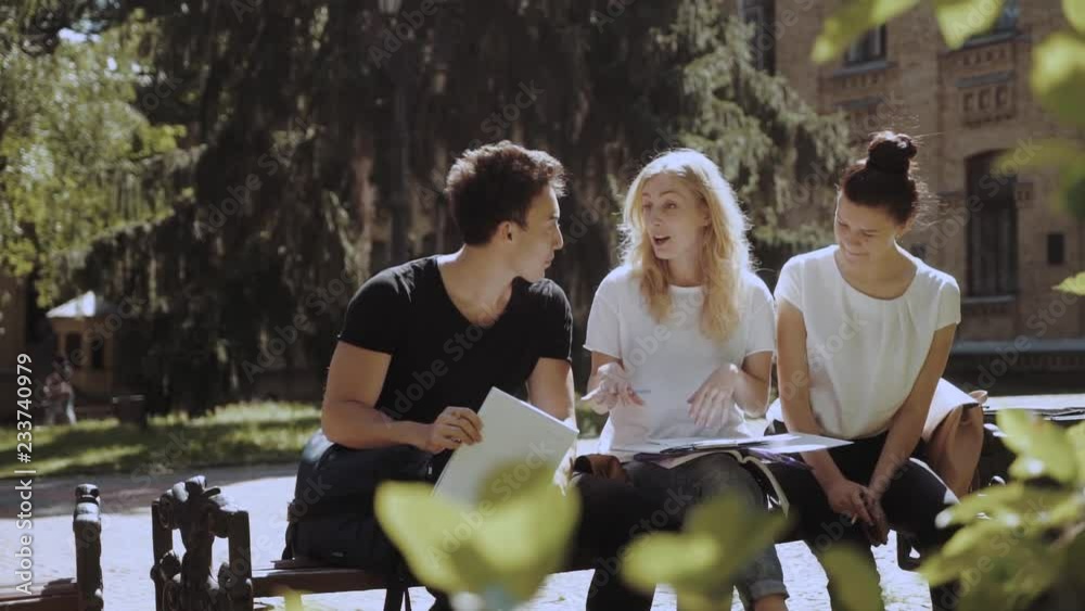 Sneak friendly college team are laughing and discussing tasks Sneak friendly college team are laughing and discussing tasks