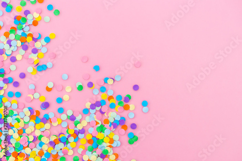 Colorful confetti on pink background.