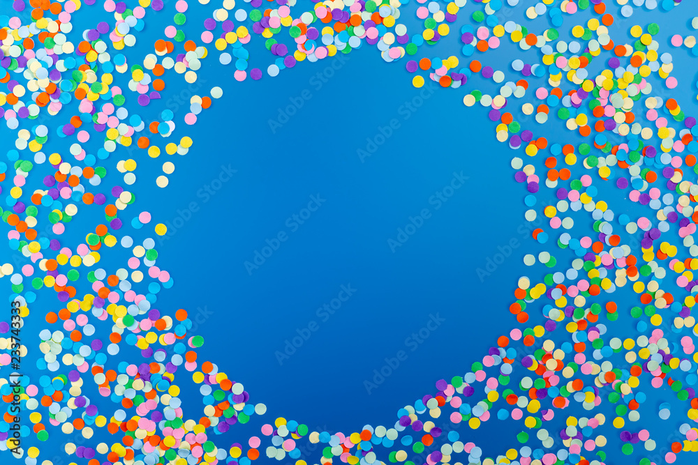 Round frame of colorful confetti on blue background. - obrazy, fototapety, plakaty 