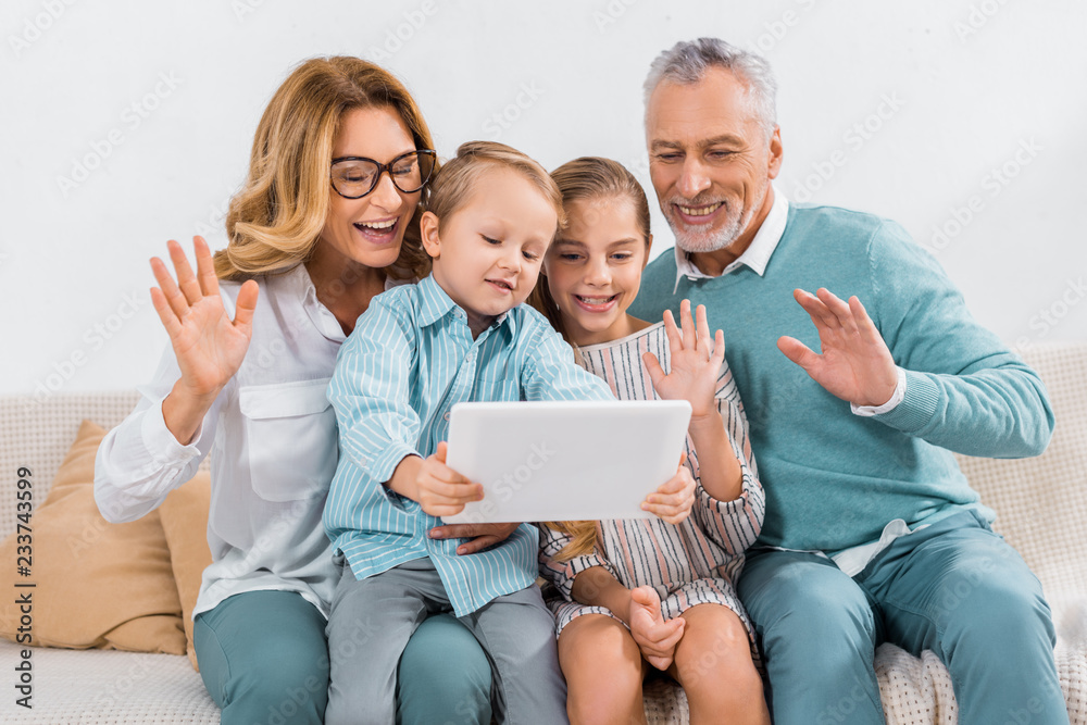 grandchildren and grandparents waving by hands while having video call with digital tablet at home grandchildren and grandparents waving by hands while having video call with digital tablet at home