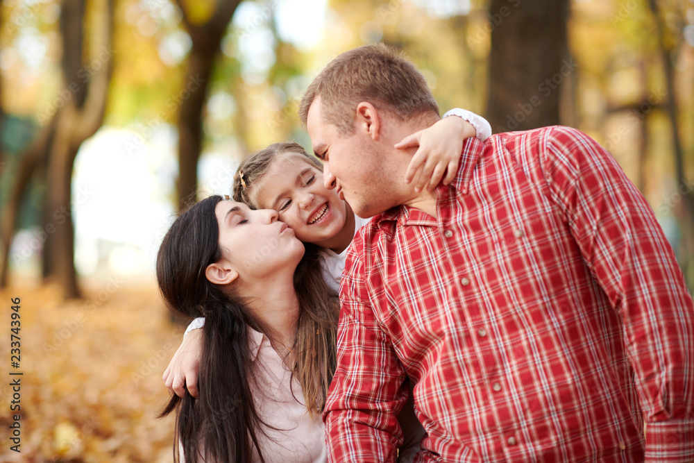 Happy family is in autumn city park. Children and parents. They posing, smiling, playing and having fun. Bright yellow trees. Happy family is in autumn city park. Children and parents. They posing, smiling, playing and having fun. Bright yellow trees.