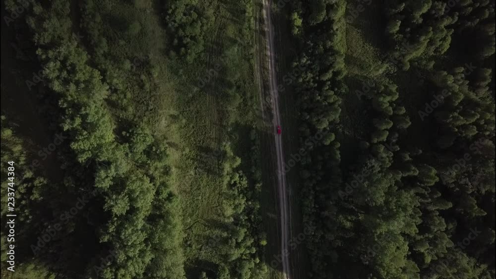 Red car on countryside road in forest. Aerial shot. Red car on countryside road in forest. Aerial shot.