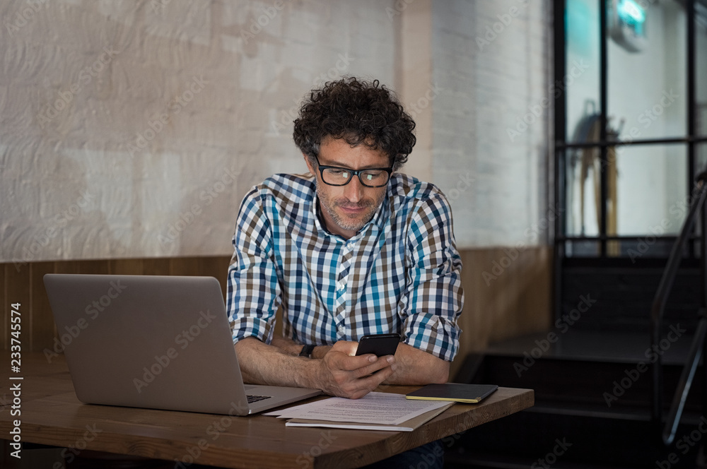 Man using laptop and smartphone at cafe Man using laptop and smartphone at cafe