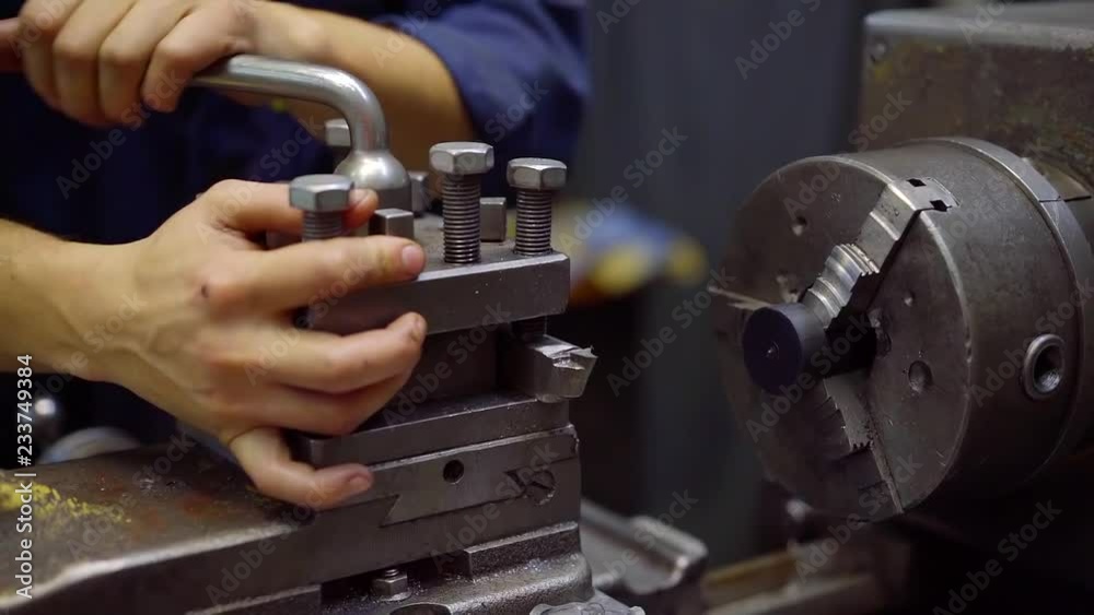 worker of plant is adjusting a rotary machine, turning handles and preparing tools for work worker of plant is adjusting a rotary machine, turning handles and preparing tools for work