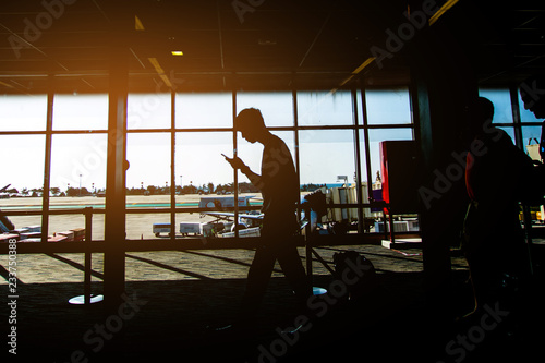 Silhouette of people walk at airport for traveling. subject is blurred and low key.