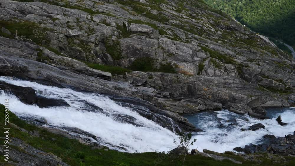 Stream or mountain river, water flows in slow motion. Norway green nature in summertime
