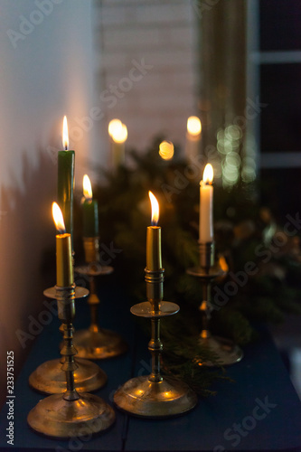 Golden candlesticks with burning candles. New Year's interior decoration.