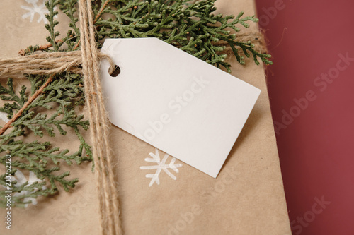 Blank Gift tag on Classy vintage Christmas gift box. Christmas presents with handmade decoration. Close up. Mockup. Copy space.