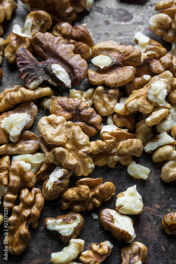 Pile of peeled walnuts on metal background