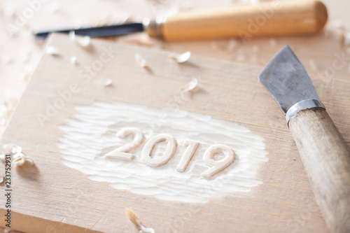Carved wooden digits 2019 of the New Year on old rustic wooden table