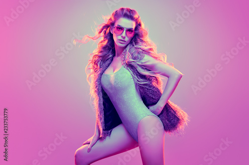 Fashion contemporary neon portrait. Beautiful woman in party glamour outfit. Disco summer vibes. Adorable fashionable sexy model girl, trendy stylish hairstyle. Creative art pink neon color 