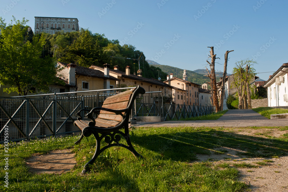 A solitary bench at the foot of the castle of Polcenigo, one of the most beautiful villages in Italy in the Province of Pordenone. Italy A solitary bench at the foot of the castle of Polcenigo, one of the most beautiful villages in Italy in the Province of Pordenone. Italy