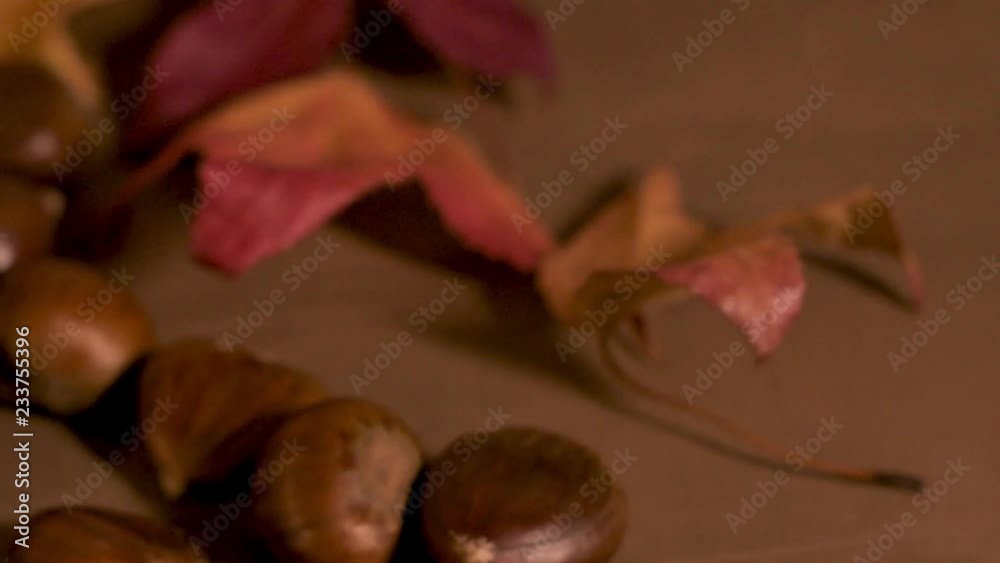 Roasted chestnuts in a paper cone, on a rustic kitchen countertop. Roasted chestnuts in a paper cone, on a rustic kitchen countertop.