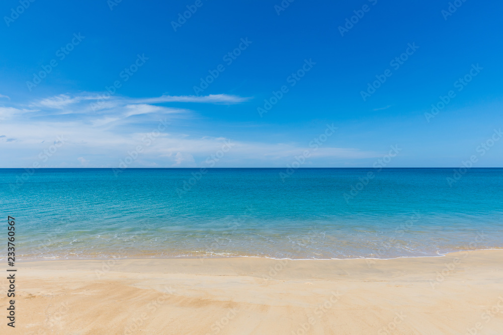 beautiful soft wave on sand at the sea with blue sky sunny day. subject is blurred.