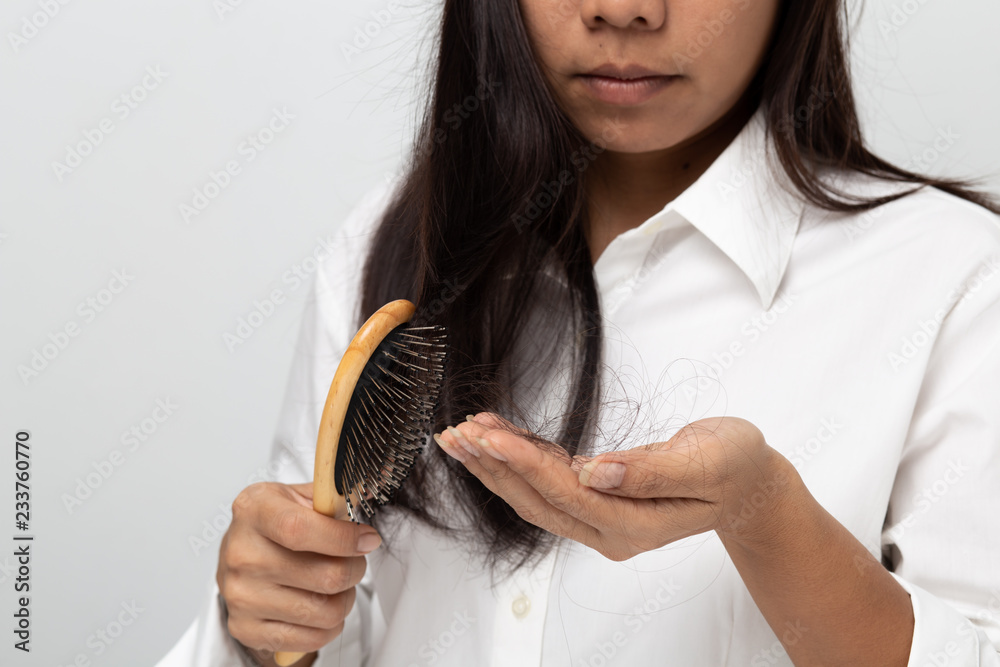woman worried about Hair loss , young asian female holds loss hair on a