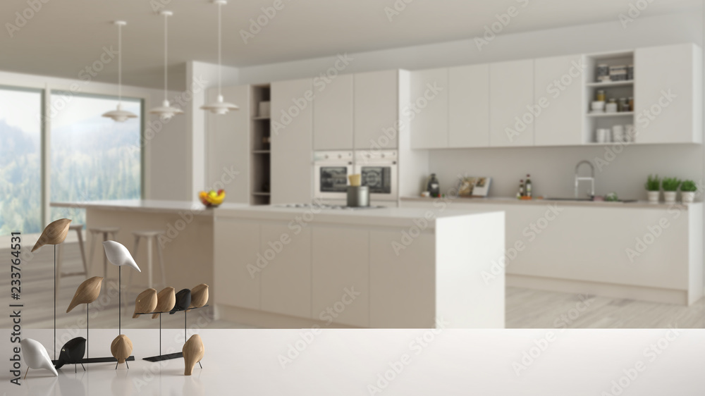 White table top or shelf with minimalistic bird ornament, birdie knick - knack over blurred modern minimalist white and wooden kitchen, modern interior design White table top or shelf with minimalistic bird ornament, birdie knick - knack over blurred modern minimalist white and wooden kitchen, modern interior design