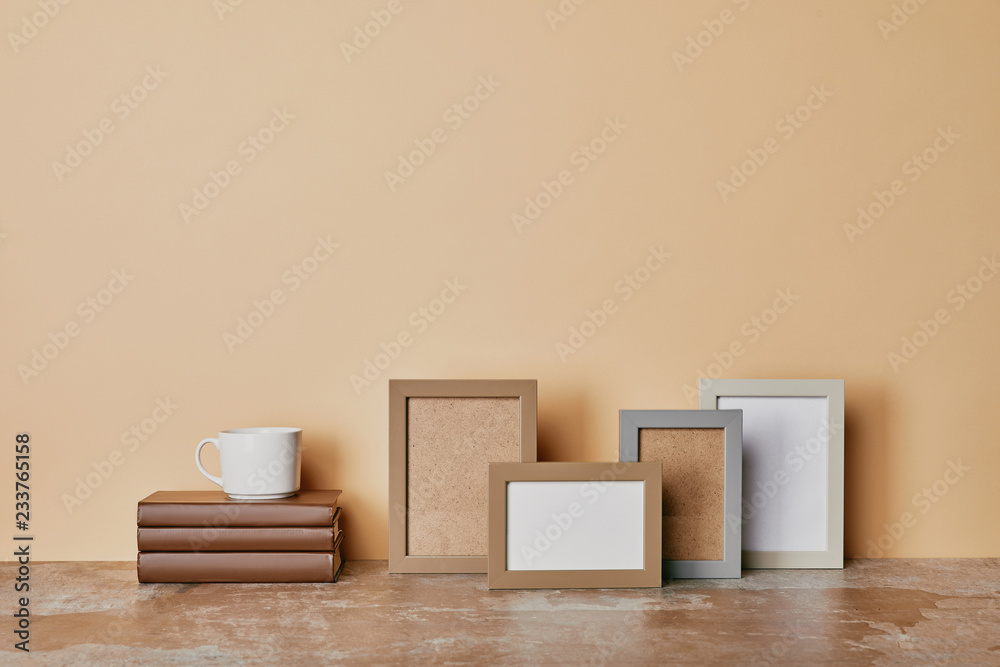 Photo frames, books and cup of coffee on beige background Photo frames, books and cup of coffee on beige background
