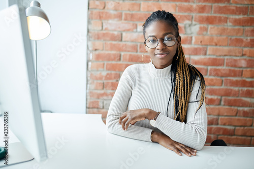 pretty awesome employeer at the table in the loft room, calm hardworking secretary in glasses photo