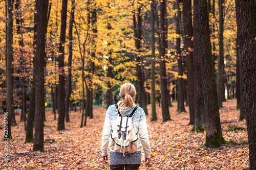 Woman with backpack walking in forest at autumn © encierro