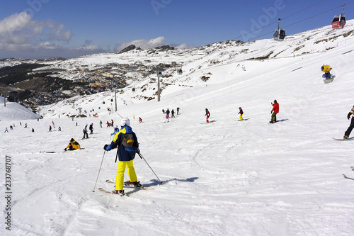 Ascenso de montaña y esquiadores que patinan desde una montaña nevada.