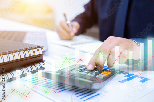 Businessman hands using calculator and Financial data analyzing at the office. photo