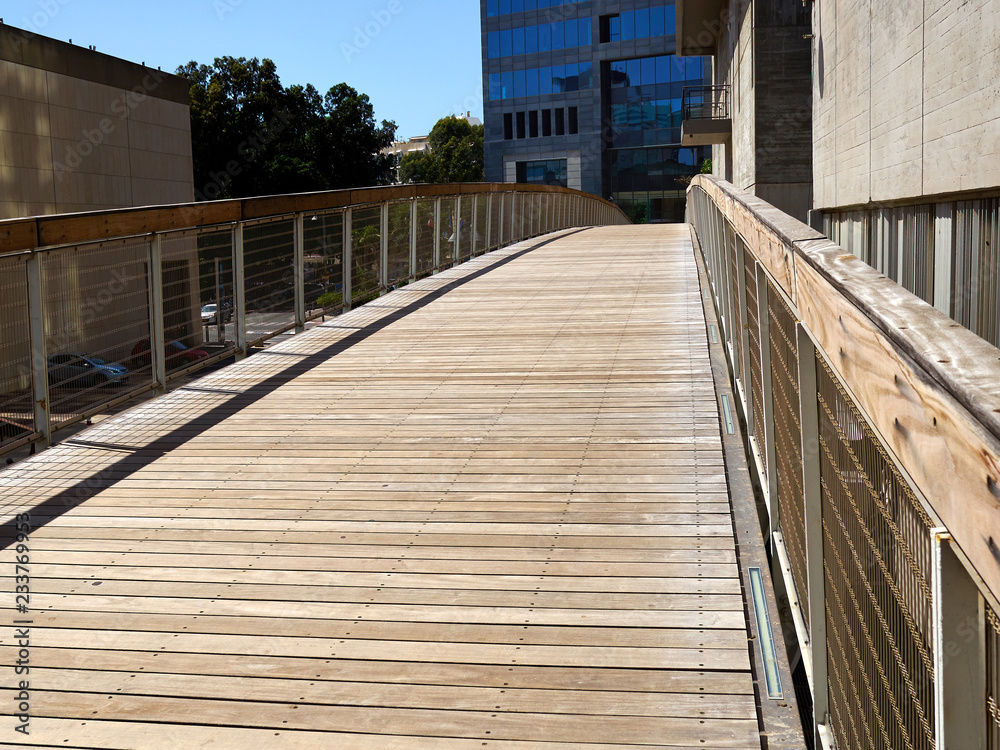 Modern bridge made of metal and wood in a city