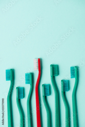 Top view of plastic colorful toothbrushes arranged on blue background