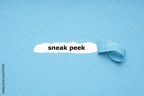 sneak peek text revealed by peeling off torn blue paper background - abstract preview concept photo