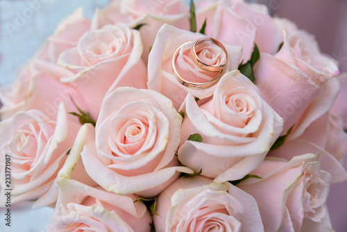 two wedding rings lying on colorful bouquet pink roses, close up © Link Art