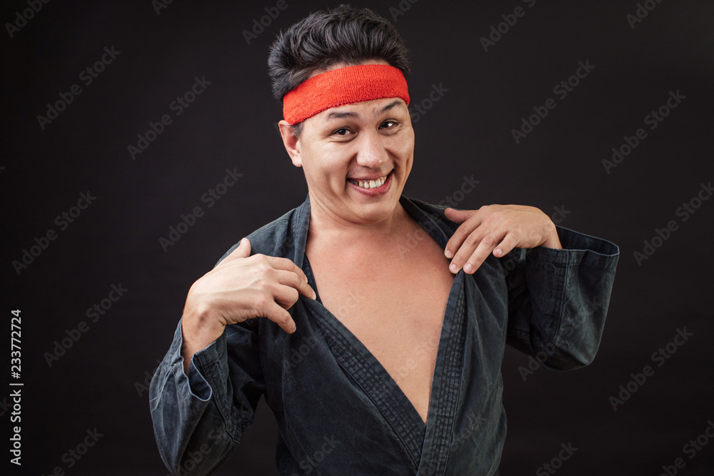 Funny karate fighter wearing black kimono flirting to the camera. Do you  like me zy smiling man tking off his kimono. role game positive guy making  sexy eyes. striptease concept. Stock Photo |
