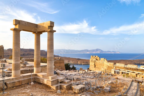 widok starożytnych portyków świątyni bogini Linda w Lindos, Rodos, Grecja, z widokiem na góry i zaskakująco piękną zatokę